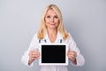 Portrait of experienced retired pensioner doc woman hold tablet use modern technology to consult corona virus patient Royalty Free Stock Photo