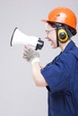 Portrait of Expressive Caucasian Female With Loudspeaker Horn Posing In Hardhat Against White Royalty Free Stock Photo