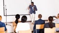 Expressive african american speaker with microphone on conference room stage Royalty Free Stock Photo