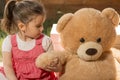 Portrait of expressive little girl hugging her toy bear Royalty Free Stock Photo