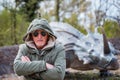 portrait of expressive middle aged man posing in front of dinosaur models in a park Royalty Free Stock Photo