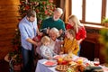 Portrait of extended happy family posing at camera behind table