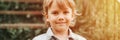 Portrait of face of a cute happy smiling little five year old dishevelled long blond caucasian preschool or homeschooler kid boy o Royalty Free Stock Photo