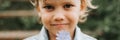 Portrait of the face of a cute happy smiling little five year old dishevelled long blond dark eyed caucasian preschool kid boy hol