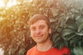 Portrait of face happy smiling mature 40+ years man solo traveler with stubble and brown eyes on the background of green trees pla Royalty Free Stock Photo