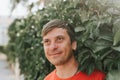 Portrait of face happy smiling unshaven mature 40+ years man solo traveler with stubble and brown eyes on the background of green Royalty Free Stock Photo