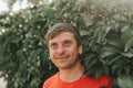 Portrait of face happy smiling unshaven mature 40+ years man solo traveler with stubble and brown eyes on the background of green Royalty Free Stock Photo