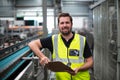 Portrait of factory worker standing with clipboard Royalty Free Stock Photo