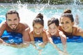 Portrait Of Family On Airbed In Swimming Pool