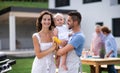 Portrait of family with baby outdoors on garden barbecue, grilling. Royalty Free Stock Photo