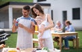 Portrait of family with baby outdoors on garden barbecue, grilling. Royalty Free Stock Photo