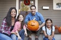 Portrait Of Family Carving Halloween Pumpkin On House Steps