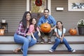 Portrait Of Family Carving Halloween Pumpkin On House Steps