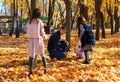 portrait of a family with children in an autumn city park, happy people walking together, playing with yellow leaves, beautiful Royalty Free Stock Photo