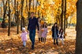 portrait of a family with children in an autumn city park, happy people walking together, playing with yellow leaves, beautiful Royalty Free Stock Photo