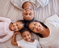 Portrait, family and children on a bed with their parents, lying together in the morning at home overhead. Love, relax Royalty Free Stock Photo