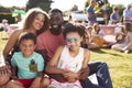 Portrait Of Family With Children Sitting On Rug At Summer Garden Fete