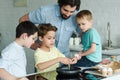 portrait of family cooking eggs for breakfast together in kitchen Royalty Free Stock Photo