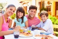 Portrait Of Family Eating Meal At Outdoor Restaurant