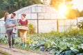 Portrait of a family of famers carrying their vegetables home in wooden boxes, at the end of the day, the Father is carrying their Royalty Free Stock Photo