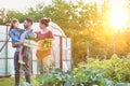 Portrait of a family of famers carrying their vegetables home in wooden boxes, at the end of the day, the Father is carrying their Royalty Free Stock Photo