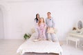 Portrait of family fighting pillows, jumping on bed together in Royalty Free Stock Photo