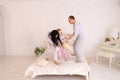 Portrait of family jumping on bed looking at camera together in Royalty Free Stock Photo