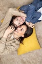 Portrait of a family, mother and teenage son lying on pillows, hugging, looking at each other, smiling, having fun Royalty Free Stock Photo