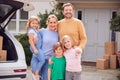 Portrait Of Family Outside New Home On Moving Day Unloading Boxes From Car Royalty Free Stock Photo