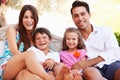 Portrait Of Family Sitting On Seat In Garden At Home Royalty Free Stock Photo