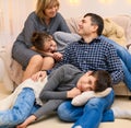 Portrait of a family sitting on a sofa at home, four people having fun together