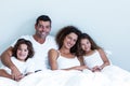 Portrait of a family sitting together on bed Royalty Free Stock Photo