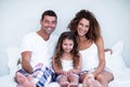 Portrait of a family sitting together on bed Royalty Free Stock Photo