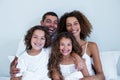 Portrait of family sitting together on bed Royalty Free Stock Photo