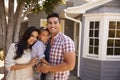 Portrait Of Family Standing Outside Home