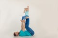 Portrait of family wearing blue T-shirts, jeans. Little smiling girl with short fair hair sitting on mans feet. Family. Royalty Free Stock Photo