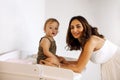 Portrait of family young mother standing near changing table with cute little baby boy on it Royalty Free Stock Photo