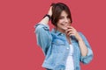 Portrait of fancy beautiful brunette young woman with makeup in denim casual style standing holding her hair and looking at camera Royalty Free Stock Photo