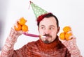 Portrait of Man on holiday in hat and whistle with tangerines