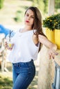 Portrait of a fantastic young girl posing next to flower pot outside in the park