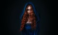 Portrait fantasy gothic red-haired woman witch. Vampire girl in blue medieval dress, vintage old historical style hood Royalty Free Stock Photo