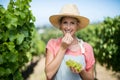 Portrait of farmer eating grapes at vineyard