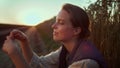 Portrait farmer examining wheat spikelets at golden summer sunset at farmland.