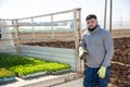 Portrait of farmer near to car with lettuce seedlings