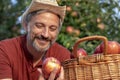 Portrait of a Farmer in a Straw Hat With A Basket of Appetizing Red Apples Royalty Free Stock Photo