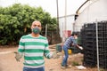 Portrait of farmer wearing protective mask in the backyard of house