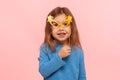 Portrait of fascinating cute little girl looking at camera through paper glasses and smiling, child playing, having fun Royalty Free Stock Photo