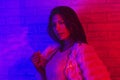 Portrait fashion of an Asian woman in neon-violet and red light  that shines in the dark with beauty and sexy, seductive, charming Royalty Free Stock Photo