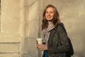 Portrait of fashion a beautiful woman with a cup of coffee in hand on the background wall