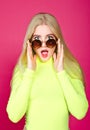 Portrait of fashion blonde surprised smiling model girl young woman wearing stylish with sunglasse isolated on a pink Royalty Free Stock Photo